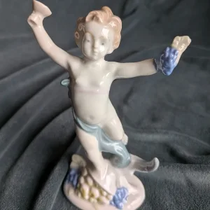 Porslinsfigur Putto med druvor och bägare, vit/blå glasyr